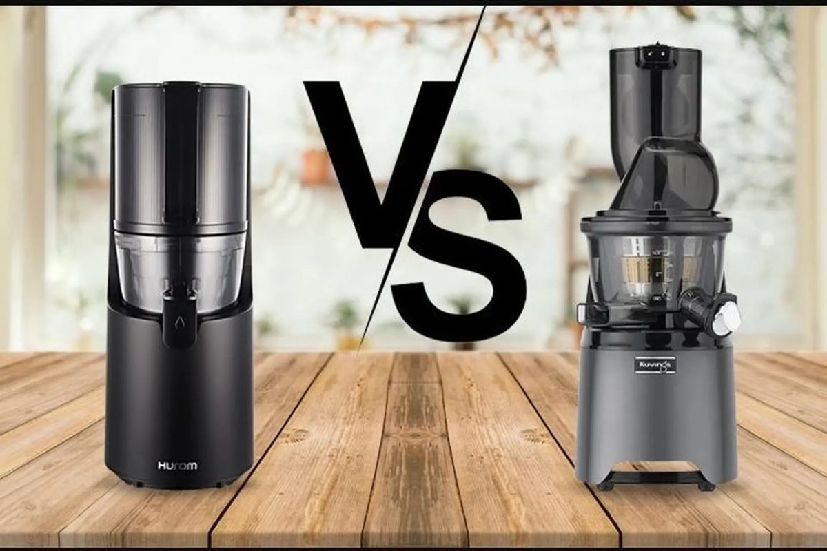 so sánh máy ép chậm Hurom H400 và Kuvings REVO830 đặt cạnh nhau trên bàn bếp đá Marble sang trọng, bên cạnh là ly nước ép cần tây xanh mướt