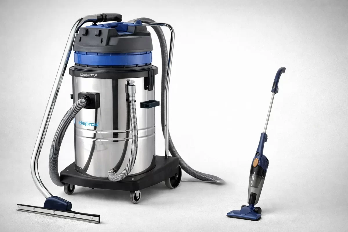 Bức ảnh so sánh trực quan: Một chiếc máy hút bụi công nghiệp vỏ Inox to đùng như cái thùng phuy mini nằm bên cạnh một chiếc máy hút bụi gia đình bằng nhựa nhỏ nhắn, xinh xắn